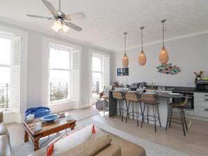 a living room with a couch and a kitchen at Sunrise Apartment in Weymouth