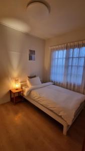 - une chambre avec un lit doté d'une lampe et d'une fenêtre dans l'établissement Stay be oom, à Jeju