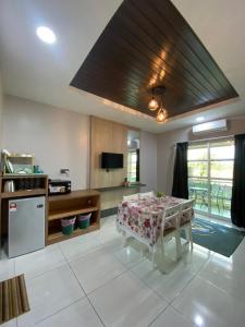 a living room with a table and a kitchen at Grand Village Inn in Pantai Cenang