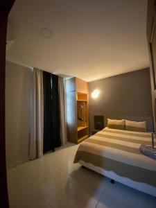 um quarto com uma cama grande e uma janela em Grand Village Inn em Pantai Cenang