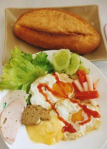 a plate of food with an egg and a loaf of bread at Neko Homestay Hue in Hue