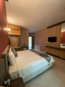 a bedroom with a large bed and a television at Grand Village Inn in Pantai Cenang