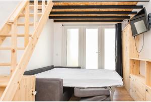 Cette petite chambre comprend un lit et une télévision. dans l'établissement Villa des palmiers, à Villeneuve-sur-Lot