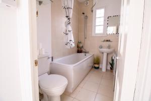 a bathroom with a tub and a toilet and a sink at Seymour Place, Hyde Park, Edgware Road London Apartments in London
