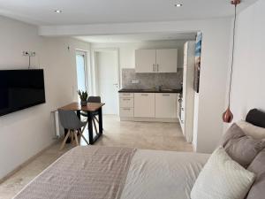 a bedroom with a bed and a table and a kitchen at 1-Zimmer Apartment in Altbach in Altbach