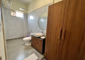 baño con aseo, lavabo y puerta en One Earth Santu Eco Resort, 