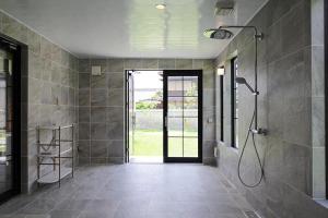 a bathroom with a shower and a glass door at Kuwayama Bettei in Mitoyo