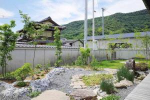 a garden in front of a house with a fence at Kuwayama Bettei in Mitoyo