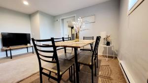 a dining room with a table and chairs and a television at Spacious Vacataion Home in Gorgeous Neighbourhood in Victoria