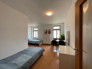 ein Schlafzimmer mit einem Bett und einem Schreibtisch in einem Zimmer in der Unterkunft Wohnglück Dresden in Dresden