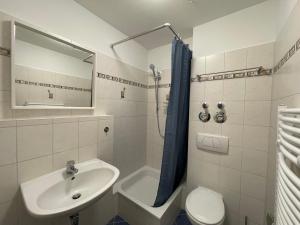 ein Badezimmer mit Waschbecken, Toilette und Spiegel in der Unterkunft Wohnglück Dresden in Dresden