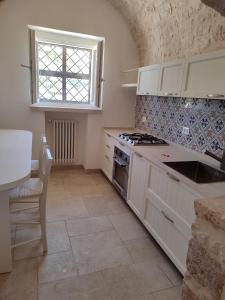 eine Küche mit einem Herd, einem Waschbecken und einem Fenster in der Unterkunft Villa don peppe in Selva di Fasano