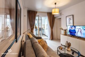 ein Wohnzimmer mit Sofa und Fernseher in der Unterkunft Central Residence Apartment 1011 in Vatra Mînăstirii Cotroceni