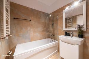ein Badezimmer mit Badewanne und Waschbecken in der Unterkunft Central Residence Apartment 1011 in Vatra Mînăstirii Cotroceni + 30 Fotos