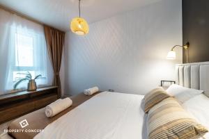 ein Schlafzimmer mit einem großen weißen Bett mit einem Fenster in der Unterkunft Central Residence Apartment 1011 in Vatra Mînăstirii Cotroceni