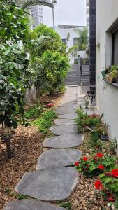 une passerelle dans un jardin à côté d'un bâtiment dans l'établissement נקודות ריפוי, à Tirat Karmel