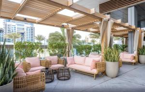 Un patio con sillas rosas y plantas en macetas. en Palm Tower Stylish Studio02 with Sea View Infinity Pool, en Dubái