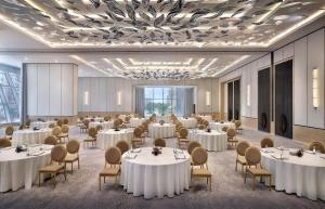 Un salón de banquetes con mesas y sillas blancas. en Palm Tower Stylish Studio02 with Sea View Infinity Pool, en Dubái