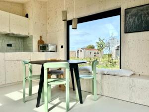 a kitchen with a table and chairs and a window at Hello Zeeland - Tiny House Zeeuwse Liefde 5 in Westkapelle