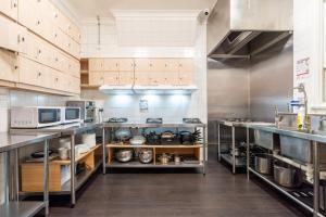 a large kitchen with stainless steel cabinets and appliances at Tequila Sunrise Hostel Sydney in Sydney