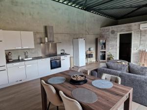 cocina y sala de estar con mesa de madera y sillas en Klein duimpje, en Echt