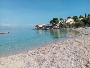 una playa de arena con casas y agua en Apartmani Afrodita en Sutivan