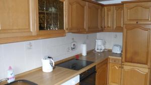 a kitchen with wooden cabinets and a counter top at Haus-zur-Entspannung in Albertsdorf +2 photos