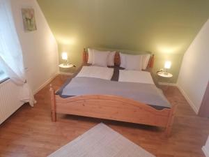 una camera da letto con un grande letto in legno con due lampade di Haus-zur-Entspannung a Albertsdorf