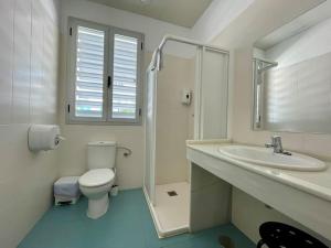 a white bathroom with a toilet and a sink at Geysotur Torrox Playa Apartamentos in Torrox +67 photos