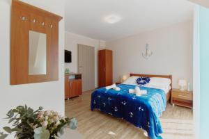 グジボボにあるVilla Konwaliaのベッドルーム1室(青いシーツと鏡付きのベッド1台付)