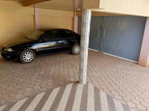 un coche aparcado en un garaje junto a un poste en Résidence lynda prestige Ouaga 2000, en Ouagadougou