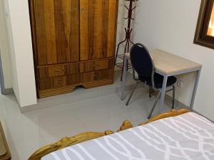1 dormitorio con escritorio, mesa y silla en Résidence lynda prestige Ouaga 2000, en Ouagadougou