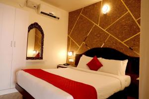 a bedroom with a large bed and a mirror at Lagoona Beach Resort in Kovalam