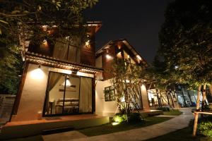 a house with lights on the side of it at night at Baanrongmai Canal Front Cafe & Homestay in Bang Chak