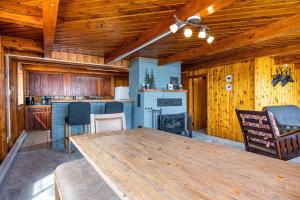 - une cuisine avec une grande table en bois dans une cabine dans l'établissement 3BR Fife Lake Getaway with Fire Pit & Hot Tub, à Fife Lake