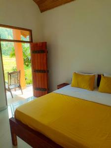 a bedroom with a large yellow bed and a sliding glass door at Sinharaja Serenity Retreat in Deniyaya