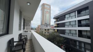 un balcón con 2 sillas en el lateral de un edificio en HOTEL CATALUÑA - SOLUCIONES HOTELERAs en Pereira
