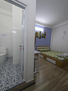 Habitación con 2 camas y baño con aseo. en Le Nhim Homestay, en Ho Chi Minh