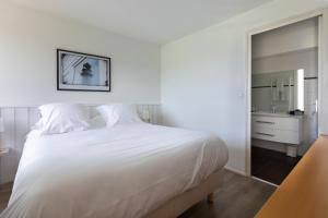 キブロンにあるLouison Appart & Suiteのベッドルーム(大きな白いベッド1台、鏡付)