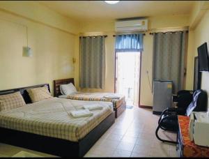 Habitación de hotel con 2 camas y TV en Sonya Residence, en Patong Beach