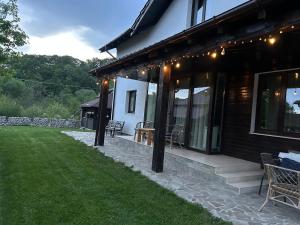 a house with a porch with lights on it at Pensiunea Eden in Bărăşti