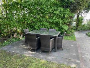 - une table avec des chaises en osier sur la terrasse dans l'établissement Apartment Köln Porz, à Cologne