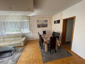 ein Wohnzimmer mit Tisch und Stühlen und einer Couch in der Unterkunft Apartment Köln Porz in Köln