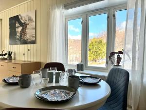 a dining room table with plates and glasses on it at A pearl in Lofoten in Leknes