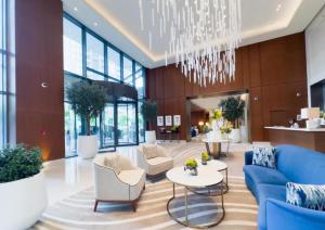 a lobby with a blue couch and chairs and a chandelier at Address Dubai Opera Residences in Dubai