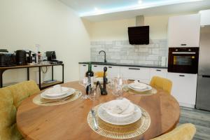 - une cuisine avec une table en bois, des assiettes et des verres à vin dans l'établissement Loft Near Basel Airport, à Hésingue