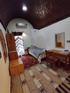 a bedroom with a bed and a desk in a room at Alexander Lodge in Siwa +27 photos