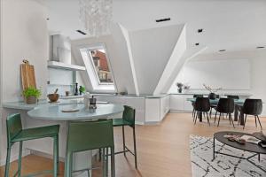 a kitchen and living room with a table and chairs at Exclusive Penthouse with Terrace in Bergen