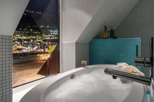a bathroom with a bath tub and a window at Exclusive Penthouse with Terrace in Bergen +30 photos