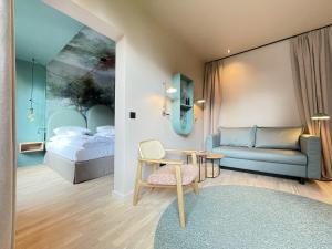 a bedroom with a bed and a couch and a table at Romantik Hotel Kieler Kaufmann in Kiel